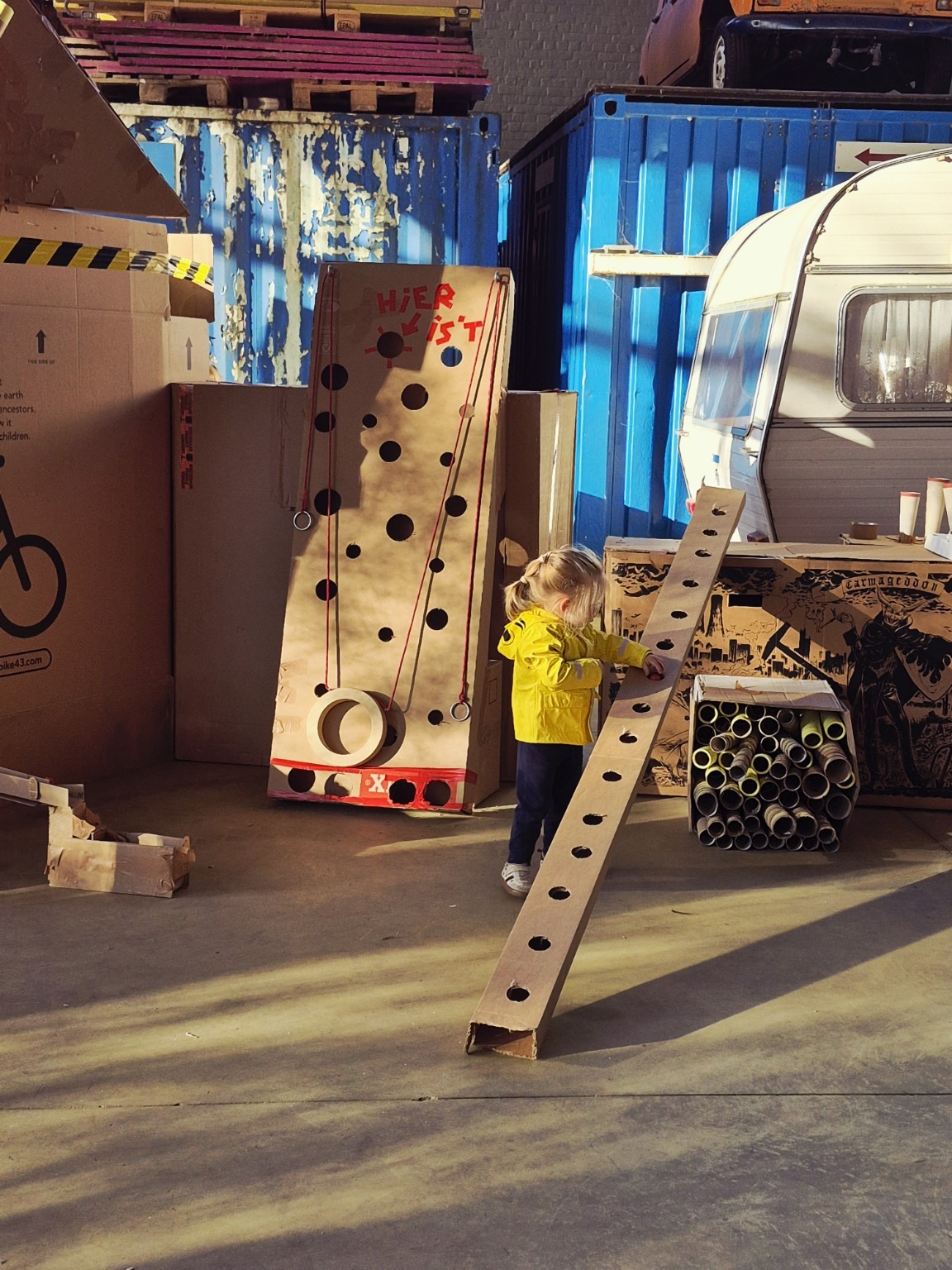 Een kind ontdekt een kartonnen speelinstallatie tijdens De Werf bij Bolwerk